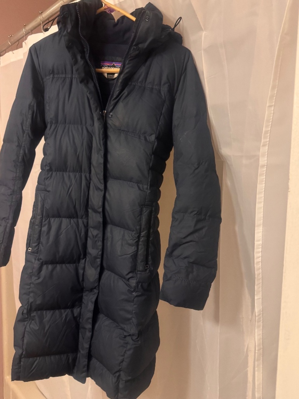 Patagonia women's long insulated parka in navy. Water-resistant shell with warm